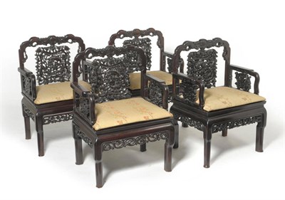 Lot 1461 - A Set of Four Chinese Carved Padouk Wood Armchairs, early 20th century, each with shaped top...