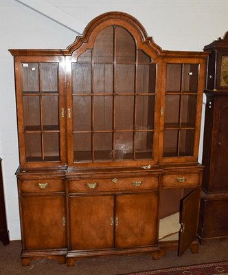 Lot 1188 - A Georgian style walnut breakfront bookcase, the central arched glazed door, flanked by two...