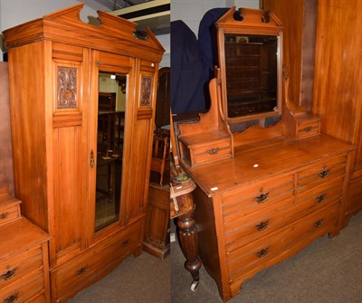 Lot 1199 - An early 20th century beech two piece bedroom suite comprising a mirrored fronted wardrobe,...
