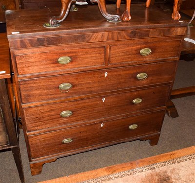 Lot 1221 - An early 19th century mahogany chest of two short over three long graduated drawers, oval gilt...