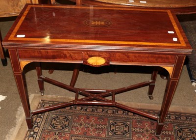 Lot 1290 - A George III mahogany and satinwood inlaid fold-over card table, rectangular form, swivel top,...