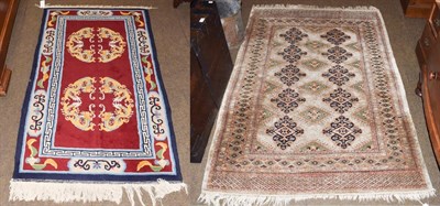 Lot 1311 - A Chinese rug, the maroon field with two dragon medallions enclosed by catouche borders, 173cm...