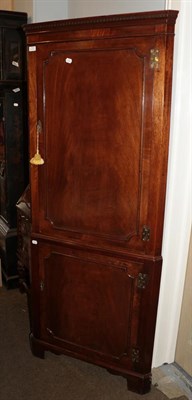 Lot 1321 - A Georgian style mahogany full-height corner cupboard, integral dentil moulded cornice above...