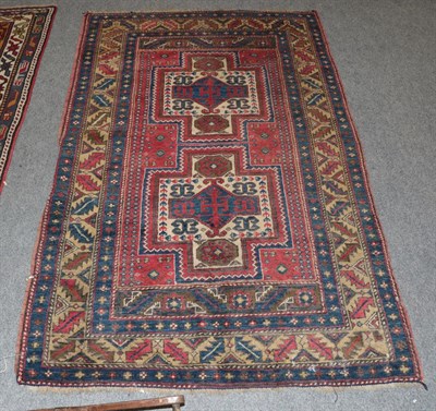 Lot 1344 - A Kazak Caucasian design rug, The terracotta field with two stepped medallions enclosed by leaf and