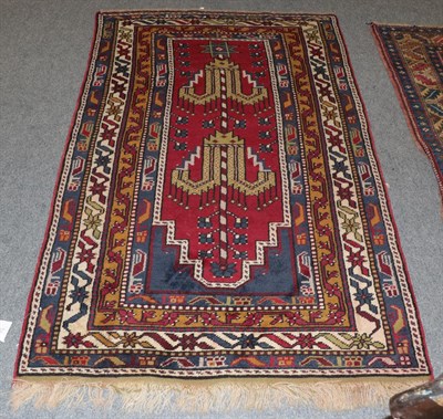 Lot 1345 - A Anatolian Prayer rug, The stepped crimson field beneath the Mihrab enclosed by multiple...