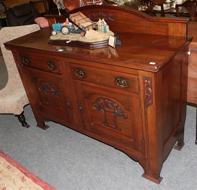 Lot 1357 - An Arts & Craft oak sideboard, carved with stylised flower and brass handles, 152cm by 54cm by 95cm