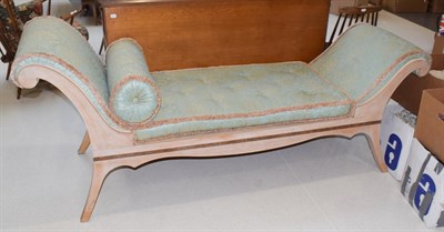 Lot 1392 - A 20th century double scroll-ended day-bed with gold and teal upholstered and a bleached wood...