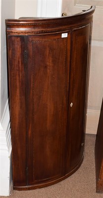 Lot 1449 - A George III inlaid mahogany bow-fronted hanging corner cupboard, 68cm by 110cm high