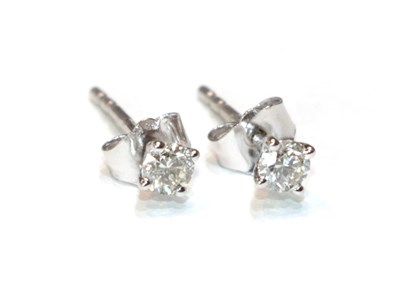 Lot 13 - A pair of 18 carat white gold diamond solitaire earrings, the round brilliant cut diamonds in...
