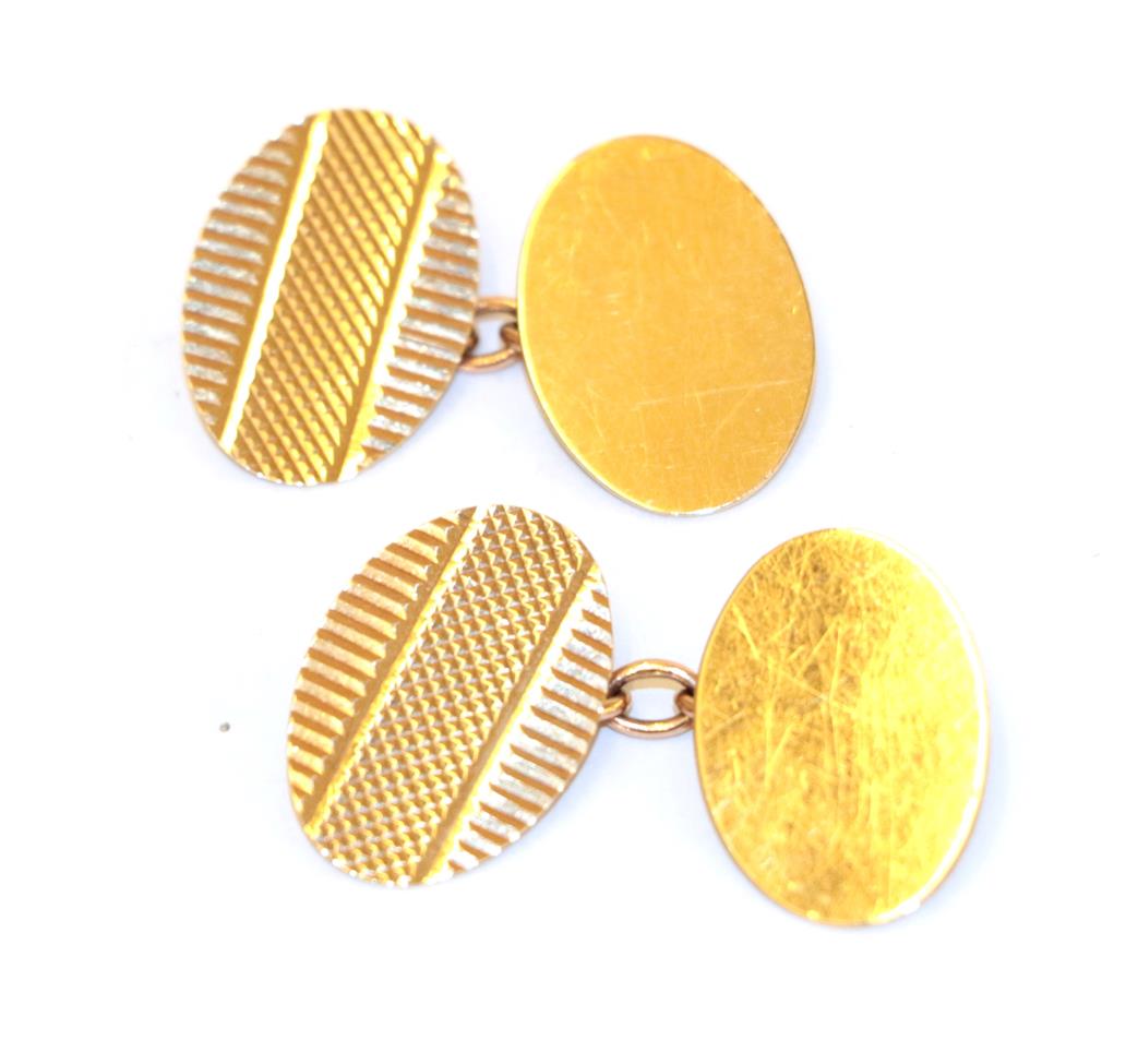 Lot 25 - A pair of 9 carat gold cufflinks, the bright cut engraved oval plaques chain linked to a plain...