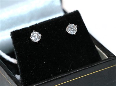 Lot 27 - A pair of diamond solitaire earrings, the round brilliant cut diamonds in white four claw settings