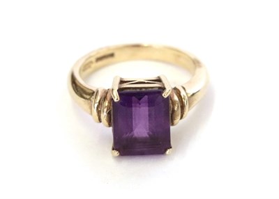 Lot 28 - A 9 carat gold amethyst ring, the emerald-cut amethyst in a yellow four claw setting, to a...