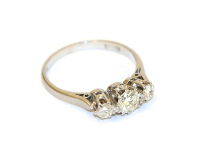 Lot 56 - A diamond three stone ring, the graduated round brilliant cut diamonds in white claw settings, to a