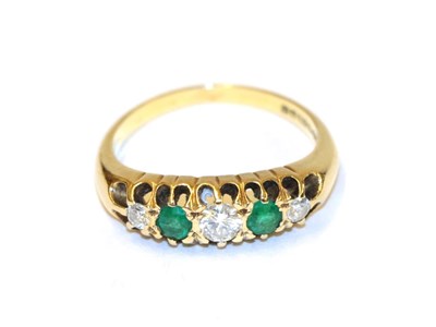 Lot 57 - An 18 carat gold emerald and diamond five stone ring, three round brilliant cut diamonds...