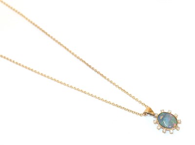 Lot 67 - A 9 carat gold black opal doublet and diamond pendant on a 9 carat gold chain, the oval black...