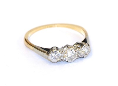 Lot 69 - A diamond three stone ring, the graduated round brilliant cut diamonds in white claw settings, to a