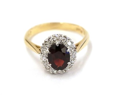 Lot 73 - A garnet and diamond cluster ring, the oval cut garnet within a border of eight-cut diamonds,...