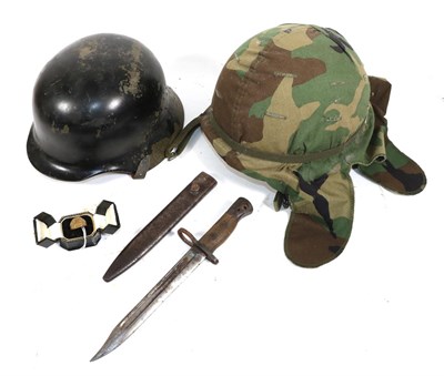 Lot 189 - A Post War German Helmet, later painted black, with folded brim, leather liner and chin strap; a US