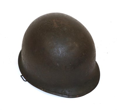 Lot 191 - A Second World War US Combat Helmet, dark green pitted finish, the inner shell inscribed in ink...