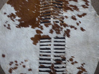 Lot 328 - Two 20th Century Zulu Cow Hide Shields, each of tan and white colouring, of elliptical form,...