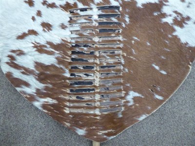 Lot 328 - Two 20th Century Zulu Cow Hide Shields, each of tan and white colouring, of elliptical form,...