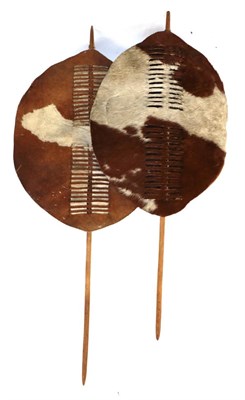 Lot 329 - Two 20th Century Zulu Cow Hide Shields, each of tan and white colouring, of elliptical form,...