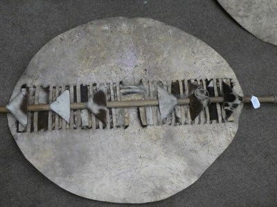 Lot 329 - Two 20th Century Zulu Cow Hide Shields, each of tan and white colouring, of elliptical form,...