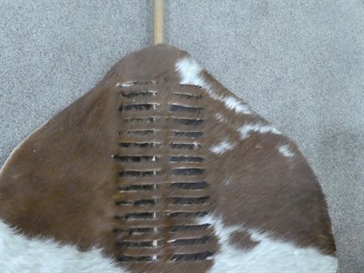 Lot 329 - Two 20th Century Zulu Cow Hide Shields, each of tan and white colouring, of elliptical form,...