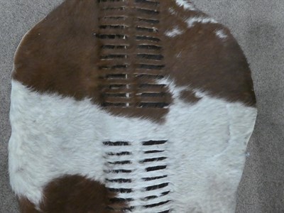 Lot 329 - Two 20th Century Zulu Cow Hide Shields, each of tan and white colouring, of elliptical form,...