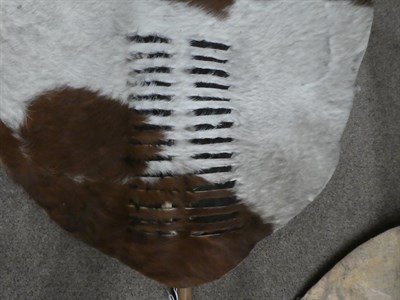 Lot 329 - Two 20th Century Zulu Cow Hide Shields, each of tan and white colouring, of elliptical form,...