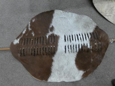 Lot 329 - Two 20th Century Zulu Cow Hide Shields, each of tan and white colouring, of elliptical form,...