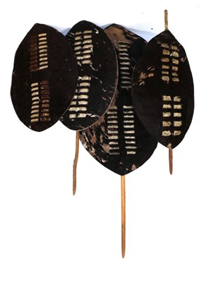 Lot 331 - A 20th Century Zulu Black Cow Hide Shields, of elliptical form, with central double band of...