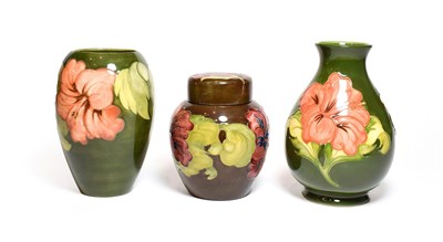 Lot 134 - Two Walter Moorcroft Coral Hibiscus pattern vases, on green grounds, impressed factory marks,...