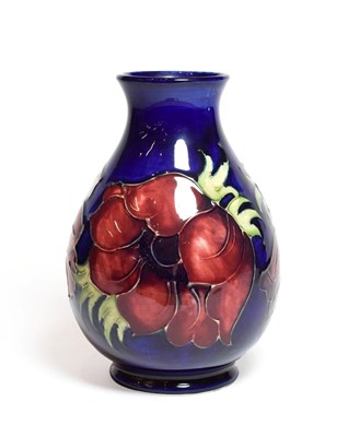 Lot 141 - A Walter Moorcroft Anemone pattern vase, on a blue ground, impressed marks, and green painted...