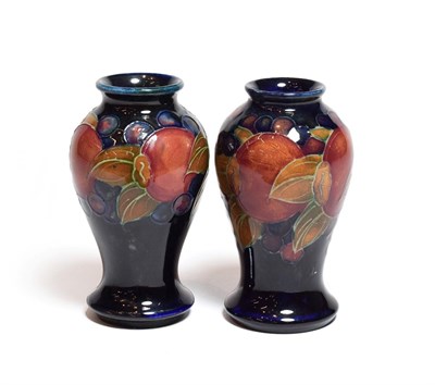Lot 142 - Two William Moorcroft Pomegranate pattern vases, on blue grounds, impressed marks, 10cm (restored)