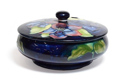 Lot 145 - A Walter Moorcroft Clematis pattern powder bowl and cover, on a blue ground, impressed factory...