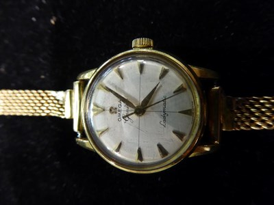 Lot 186 - A lady's 18 carat gold wristwatch signed Omega, Geneve, Ladymatic, with attached mesh bracelet with