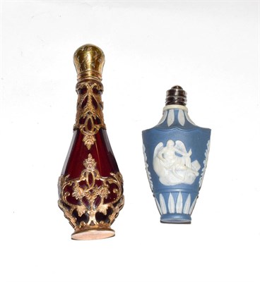 Lot 203 - A ruby-glass scent-bottle with brass mounts, pear-shaped and with openwork and engraved foliage...