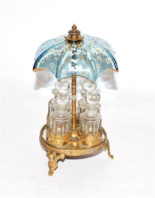 Lot 246 - A set of four glass scent bottles, in brass mounted stand with overhead enamelled blue glass...