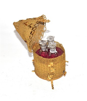 Lot 250 - A set of three scent bottles, in fitted brass box formed as a skep, on twisted wire feet and...