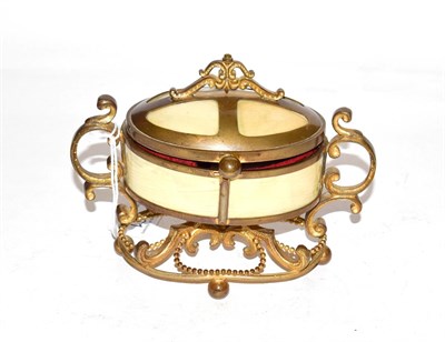 Lot 261 - A gilt-metal mounted composition box, the box oval and with scroll cast mounts, 15cm wide; together