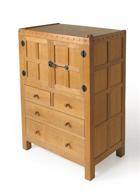 Lot 1619 - A Robert "Mouseman" Thompson Panelled Oak Tallboy, with castellated top above two cupboard...