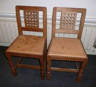 Lot 1623 - A Pair of Robert "Mouseman" Thompson Oak Lattice Back Dining Chairs, with cow hide upholstered...