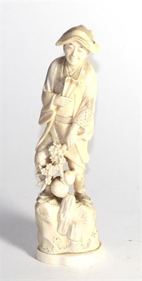 Lot 416 - A Japanese Meiji period ivory okimono of a man holding a gourd and fan, 25cm high