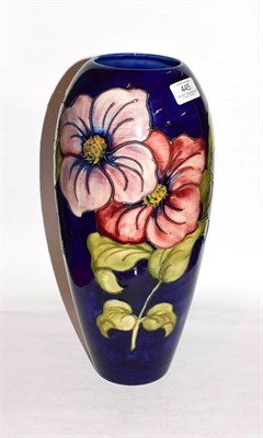 Lot 445 - A large Walter Moorcroft clematis pattern vase, on a blue ground, signed and impressed factory...