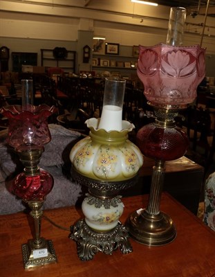 Lot 470 - Two Victorian brass oil lamps both with cranberry glass reservoirs and shades, together with a...