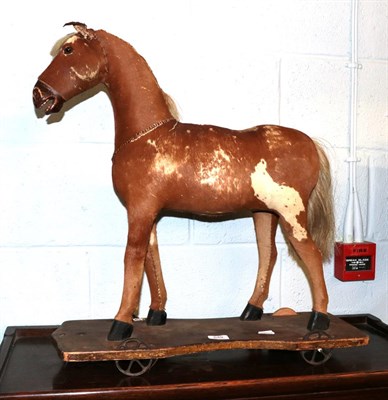 Lot 549 - A hide covered pull along horse