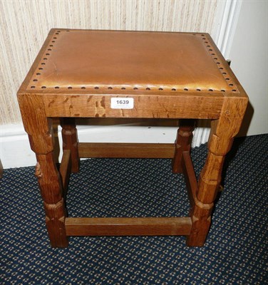 Lot 1639 - A Robert "Mouseman" Thompson Oak Stool, upholstered cow hide seat, on four turned octagonal...