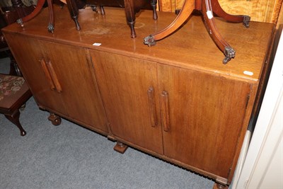 Lot 1192 - An oak four door sideboard, an oak cabinet with fall front, a pair of yew wood tripod tables, a...