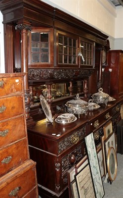 Lot 1204 - An imposing ornately carved sideboard, the upper section with leaf and scroll carved broken...